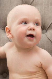 Baby sitzt nackt auf dem Sofa, Portrait Baby sitzt nackt auf dem Sofa, Portrait